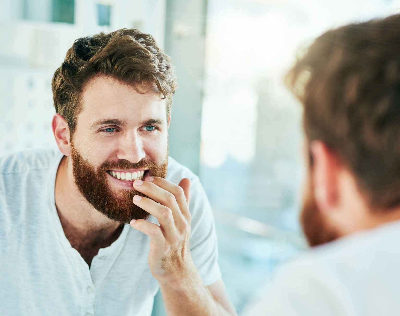 Man looking at smile in mirror