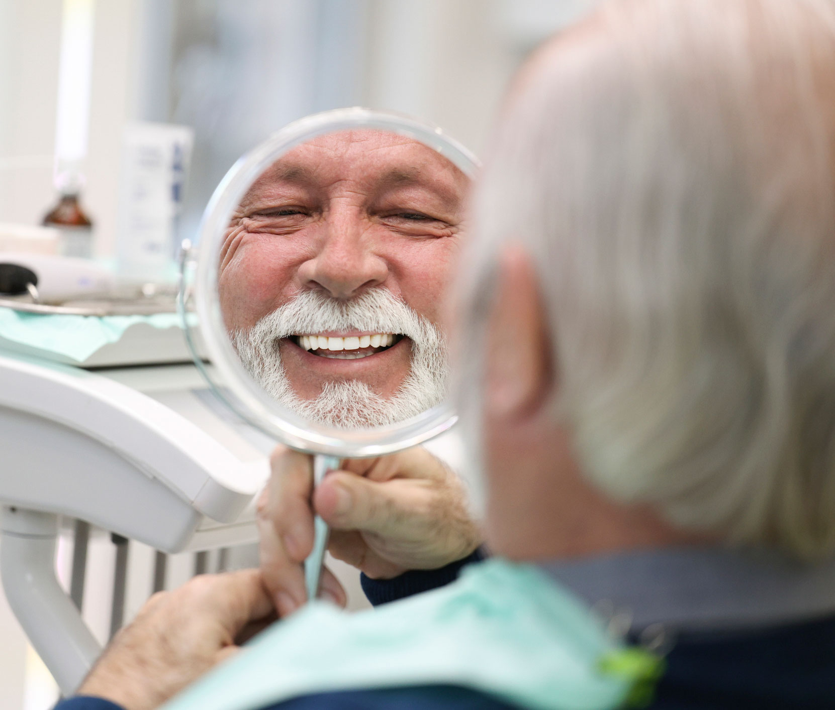 Man looking in a mirror at the dentist